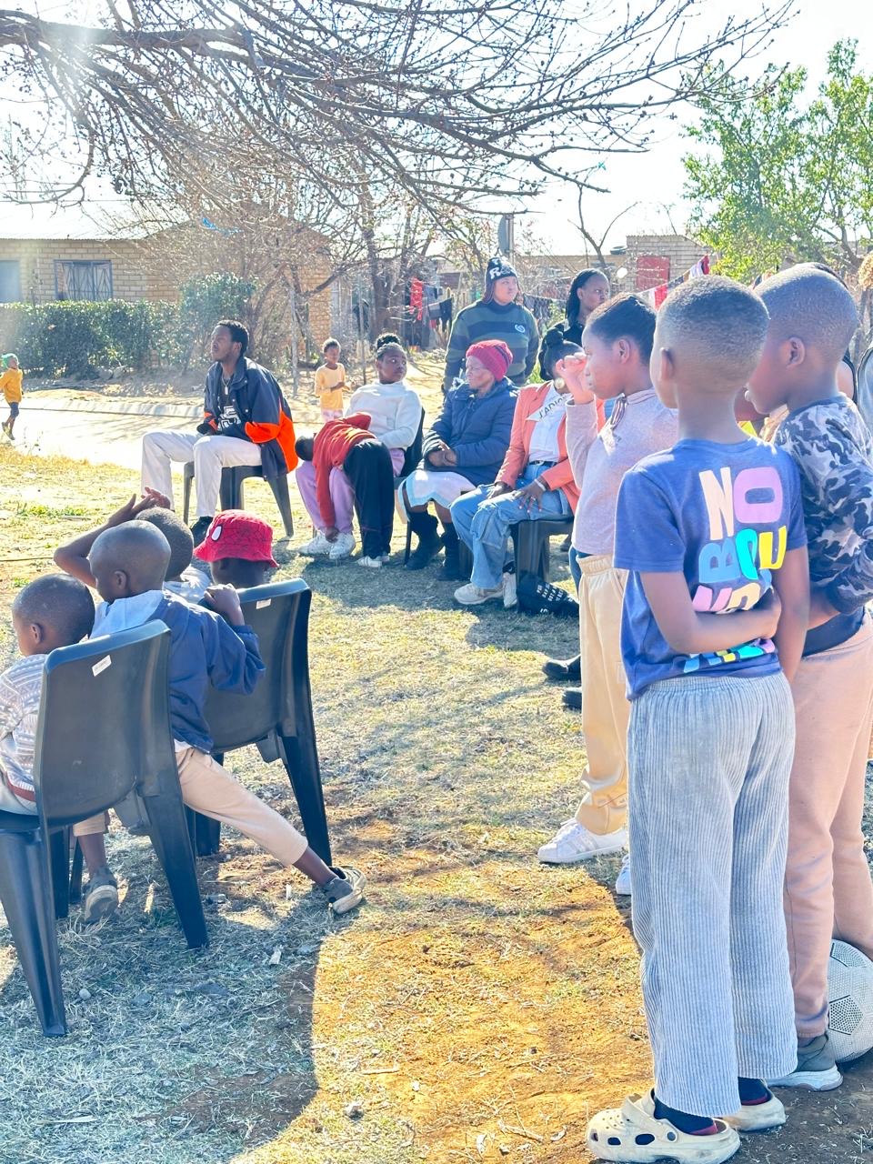 Children standing and listening during a neighbourhood gathering