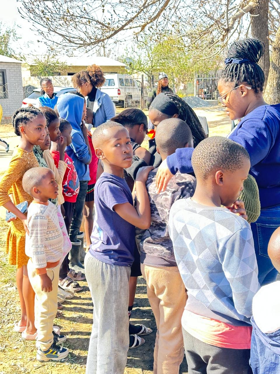 Children lining up with a volunteer at a community outreach